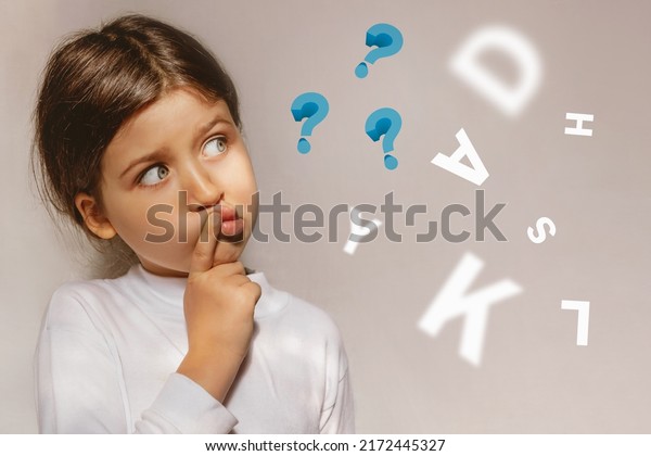 Pensive\
Girl looking away with dyslexia or dyslexia at school. Questions\
and letters. The child learns to speak\
correctly.