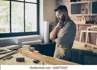 Pensive hardworking thoughtful serious concentrated minded cabinet-maker standing near table with instruments and thinking over new diy