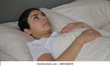 Pensive Indian Woman Laying Awake In Bed