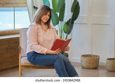 pensive lady is reading a book at home. attractive middle aged woman relaxing at home. Successful middle aged woman smiling.