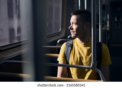 Pensive Lonely Man Looking Out Of Window Of Train. Solo Traveler In Public Transportation On Sunny Day.
