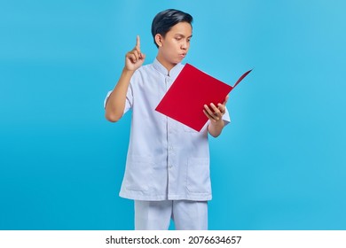 Pensive Male Nurse Pointing Finger At Folder On Blue Background