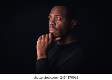 Pensive man contemplating in a dark setting - Powered by Shutterstock