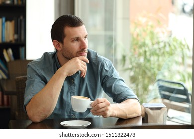 Pensive Man Contemplating Outdoors Through A Window Sitting In A Coffee Shop