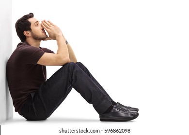 Pensive man leaning against a wall and thinking isolated on white background
