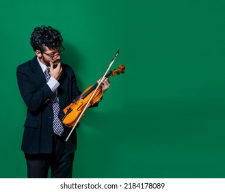 pensive man looking at the violin, Portrait of male violinist looking at his violin while thinking