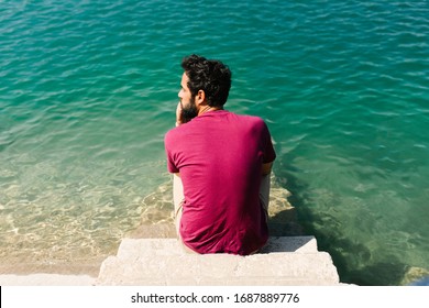 pensive man on the lakeshore - Powered by Shutterstock