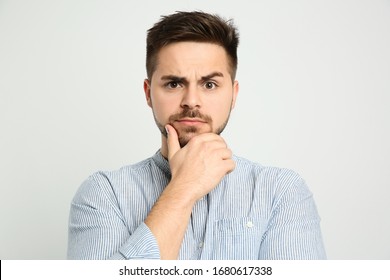 Pensive Man On Light Background. Thinking About Answer For Question