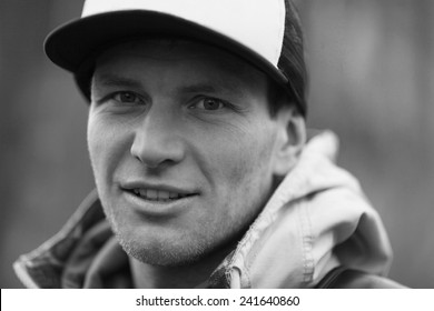 Pensive Man In A Trucker Cap. Black And White Close-up Portrait