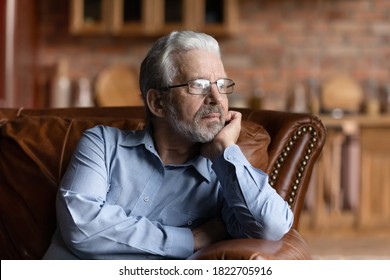 Pensive mature Caucasian grey-haired man relax on sofa in living room look in distance thinking dreaming. Thoughtful senior 70s grandfather rest on couch at home, lost in thoughts remembering missing. - Powered by Shutterstock