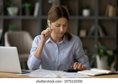 Pensive millennial woman accountant focused on paperwork prepare financial tax report think on income and costs balance calculate loan credit payments. Thoughtful young female manage business expenses