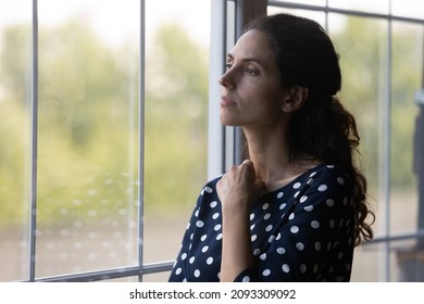 Pensive millennial woman looking out of window, lost in negative thoughts. Anxious nervous unhappy young hispanic lady making difficult decision, feeling doubtful at home, depression concept. - Powered by Shutterstock