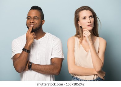 Pensive Multiracial Millennial Man And Woman Isolated On Blue Studio Background Look In Different Sides Thinking, Thoughtful Multiethnic Couple Pondering Making Decision, Having Dilemma