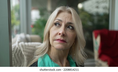 Pensive Older Woman Looking Out Window In Contemplation. Thoughtful Middle Aged Female Businesswoman Thinking Closeup Face Portrait Seated At Coffee Shop