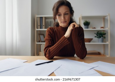 Pensive Pondering Unhappy Sad Curly Beautiful Woman Lost In Heavy Thoughts Looks Down Think About Difficult Life Decision Sitting At Home Office. People Problems Concept