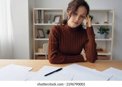 Pensive Pondering Unhappy Sad Curly Beautiful Woman Lost In Heavy Thoughts Looks Down Think About Difficult Life Decision Sitting At Home Office. People Problems Concept