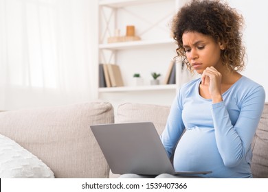 Pensive pregnant woman using laptop, remote working or surfing internet at home, free space