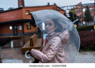 Pensive Pretty Girl Holding Umbrella While Strolling Outside On Rainy Autumn Day. Photo Looks Like Film Frame Or Movie Screenshot. Processed In Cold Colors