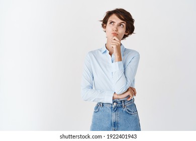 Pensive Professional Woman Looking Up And Thinking, Standing Thoughtful On White Background In Blue Collar Shirt.