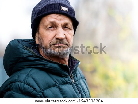 Pensive sad elderly man with a beard and mustache close-up  portrait. Russian village