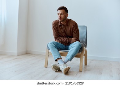 Pensive sad frustrated upset thoughtful young tanned man guy crosses hands looks aside sitting in chair at home think about difficult life situation. People emotions Problems. Depression help - Powered by Shutterstock