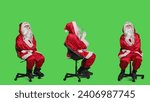 Pensive santa in costume sits on chair, thinking about christmas eve gift ideas over full body greenscreen. Young man acting like saint nick character with white beard, brainstorming.