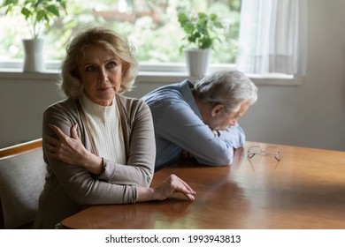 Pensive senior Caucasian woman and husband think of relationships problems, ignore each other after fight. Unhappy thoughtful old couple spouses avoid communication, think of divorce breakup.