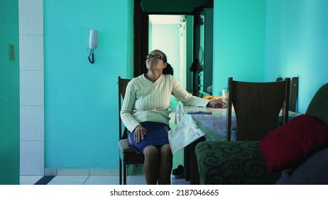 A Pensive Senior Hispanic Woman Sitting At Home Alone. A Thoughtful Black Mature Older Person