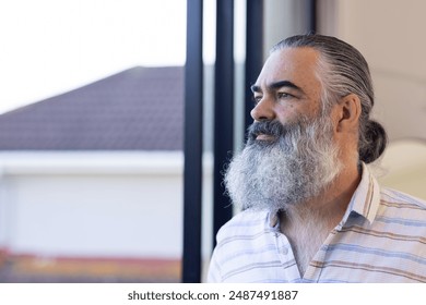 Pensive senior man with gray beard looking out window, contemplating thoughts, copy space. Contemplation, thinking, reflection, solitude, mature, wisdom - Powered by Shutterstock