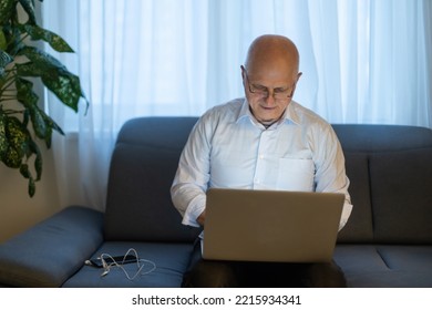 Pensive Senior Man Reading News On Laptop. Cheerful Excited Mature Male Using Portable Computer At Home, Copy Space.