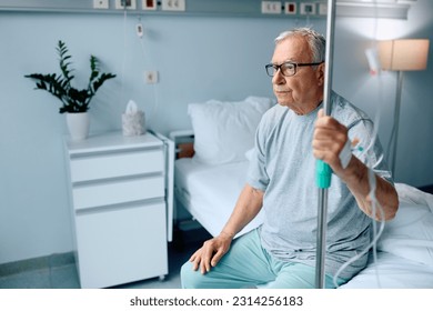 Pensive senior man sitting on hospital bed during his medical recovery. - Powered by Shutterstock