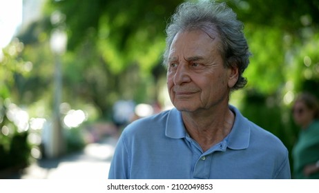 Pensive Senior Man Walking Outside In City Green Nature Path