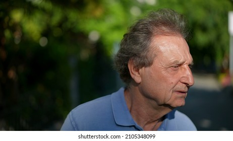 Pensive Senior Man Walking Outside In City Green Nature Path