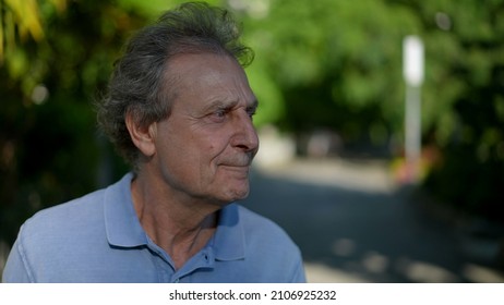 Pensive Senior Man Walking Outside In City Green Nature Path