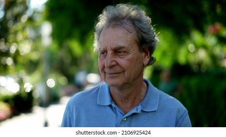 Pensive Senior Man Walking Outside In City Green Nature Path