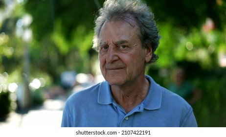 Pensive Senior Man Walking Outside In City Green Nature Path