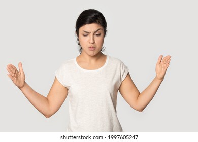 Pensive stunned Indian woman isolated on grey studio background show big size measurement copy space. Amazed mixed race female client buyer shocked by impressive good promotion deal or sale discount.