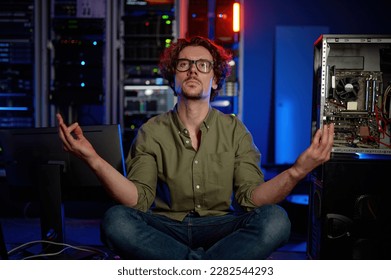 Pensive technician meditating in server room at modern data center - Powered by Shutterstock