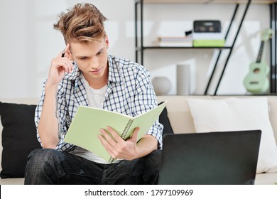 Pensive Teenage Boy Reading Information In Textbook And Trying To Memorize Things For Exam