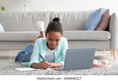 Pensive Teenager Afro American Female Student Study At Home With Laptop, Prepare For Test And Exam At Home, Lies, Doing Homework. Knowledge, Modern Education And Back To School During Social Distance