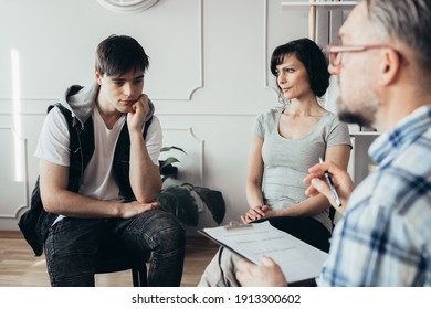 Pensive Teenager Sits Next To His Mother During A Meeting With Therapists For Children With Problems