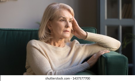 Pensive thoughtful middle aged lady looking away sit alone at home feel anxious lonely, sad depressed melancholic old mature woman suffer from sorrow grief thinking of problem suffer from solitude - Shutterstock ID 1437577700
