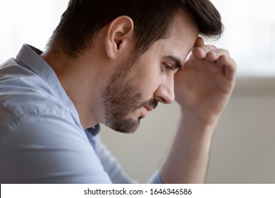 Pensive unhappy young Caucasian man lost in thoughts thinking suffering from life problems making decision, thoughtful millennial male feel distressed upset pondering or mourning having troubles