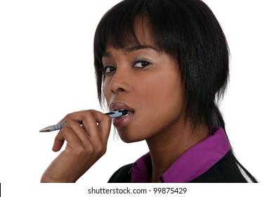 A Pensive Woman Chewing On Her Pen