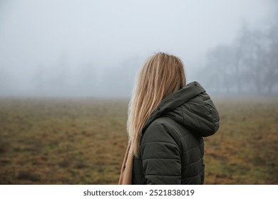 Pensive woman with hooded coat standing in fog alone. Sadness and loneliness concept - Powered by Shutterstock