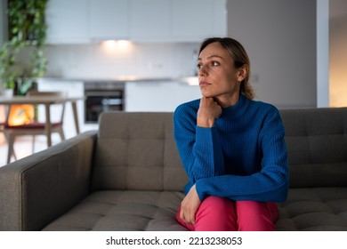 Pensive Woman Procrastinates With Office Work. Young Female Freelancer Sitting On Comfortable Sofa Looks Around Room And Thinks About Life At Home. Girl Has Melancholy And Depression. Mental Health.