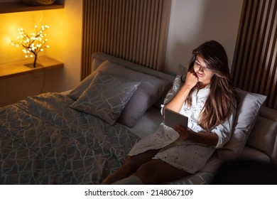 Pensive Woman Relaxing At Home Late At Night, Doing Online Shopping Using Tablet Computer