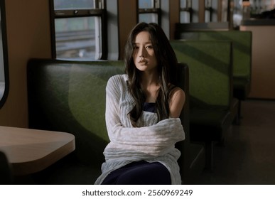 Pensive Woman Sitting Alone on a Train in Soft Natural Light, Wrapped in a Cozy Shawl for a Serene and Reflective Mood. - Powered by Shutterstock