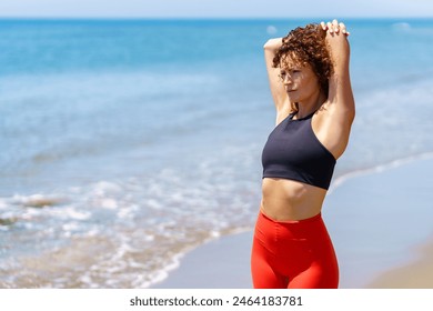 Pensive woman stretching on seashore - Powered by Shutterstock