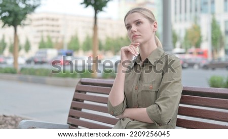 Pensive Woman Thinking while Sitting Outdoor on Bench